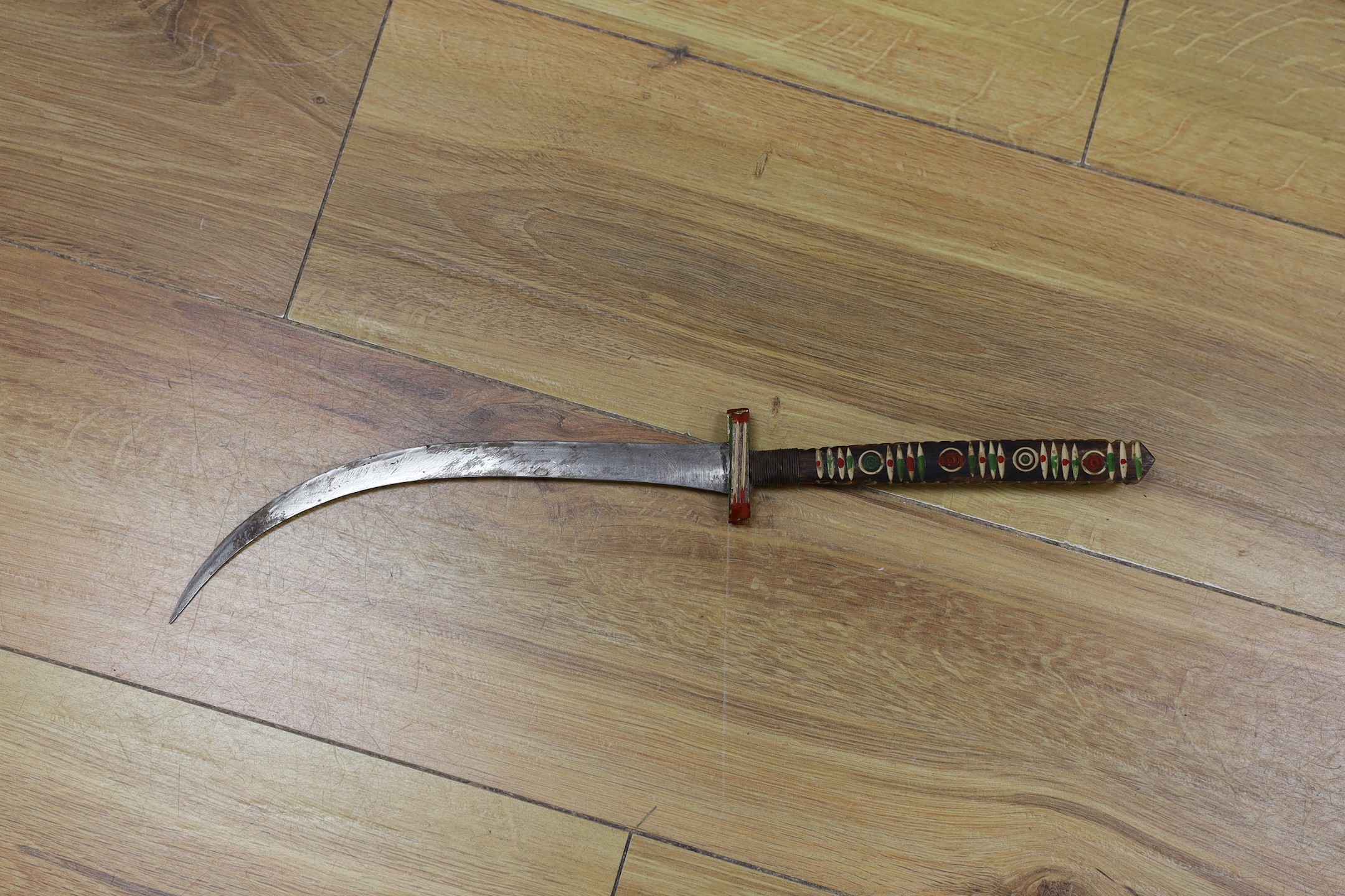 A George V military dress sword in brown leather covered scabbard, 102cm long, and a Middle Eastern dagger with carved and painted handle